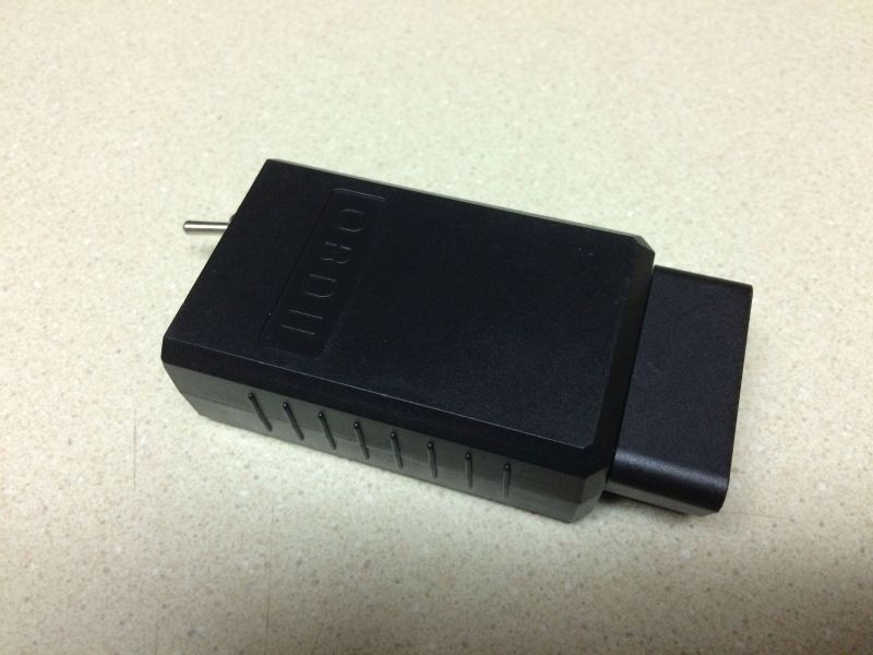 Black OBDII scanner on a speckled countertop.