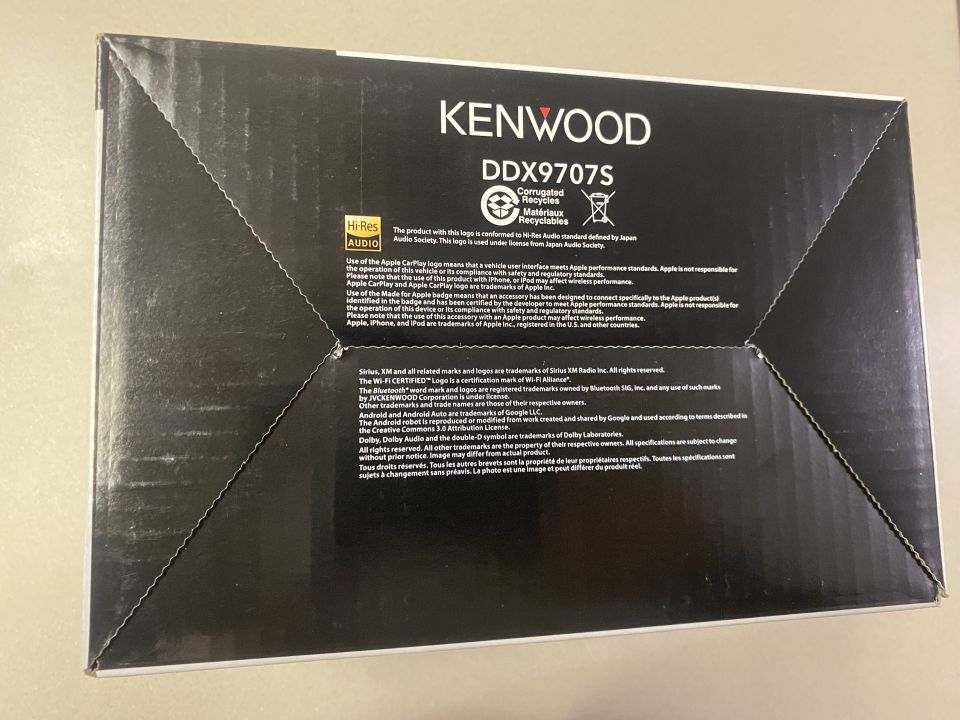 Kenwood DDX9707S car stereo box with logos and text