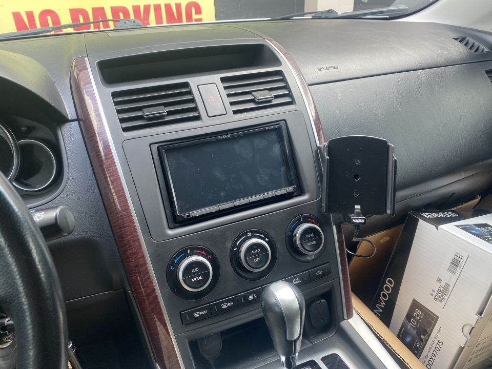 Interior of a 2009 Mazda CX-9, showing the dashboard, center console, Kenwood head unit, and climate controls.