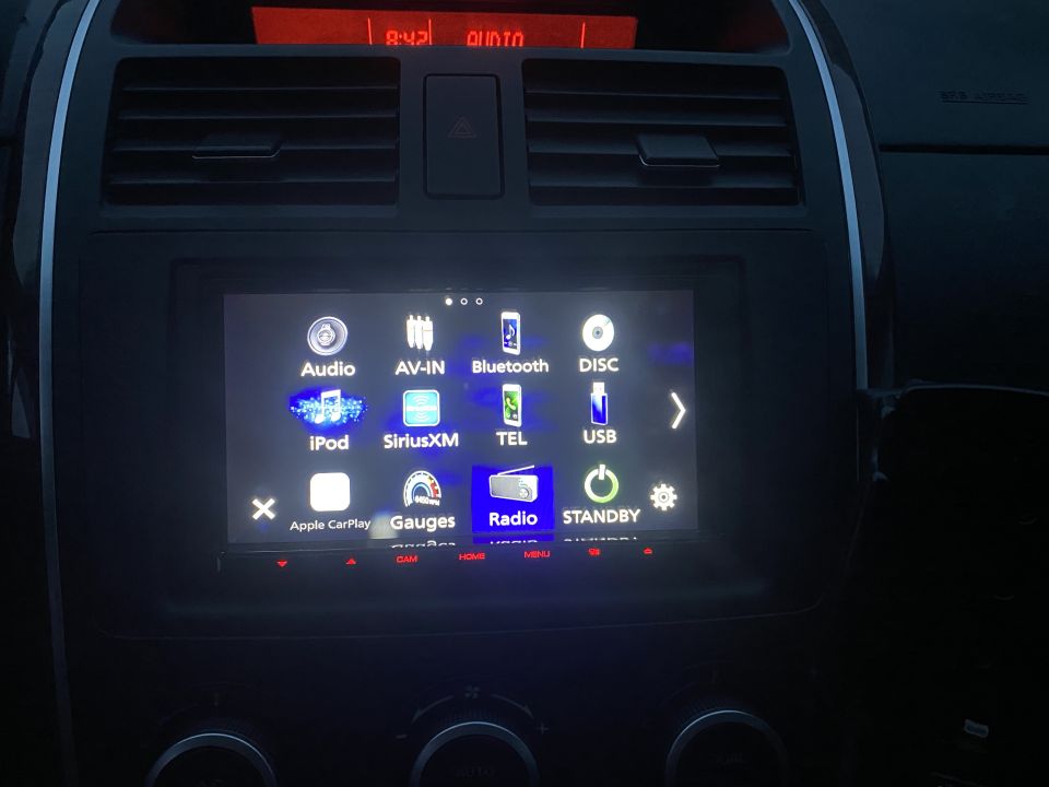 Car infotainment screen showing Audio, Bluetooth, USB, Radio, and other options.