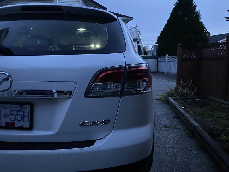 Rear driver's side view of a white Mazda CX-9 SUV.