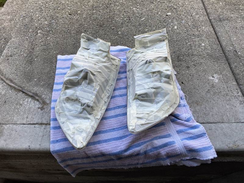 Two car parts taped off and resting on a towel.