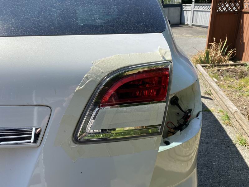 White Mazda CX-9 rear passenger side with taillight removed and taped.