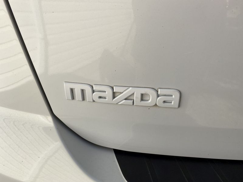 White Mazda emblem on a white vehicle.