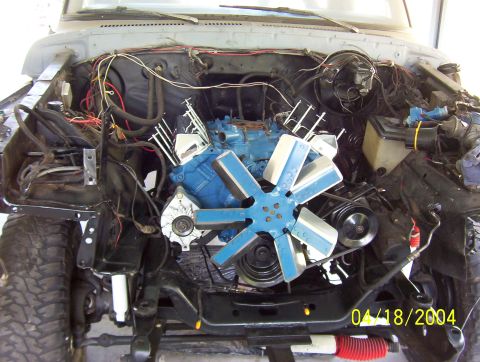 1978 Ford F-150 - The engine bay of a truck is shown with the engine partially disassembled and various wires exposed.