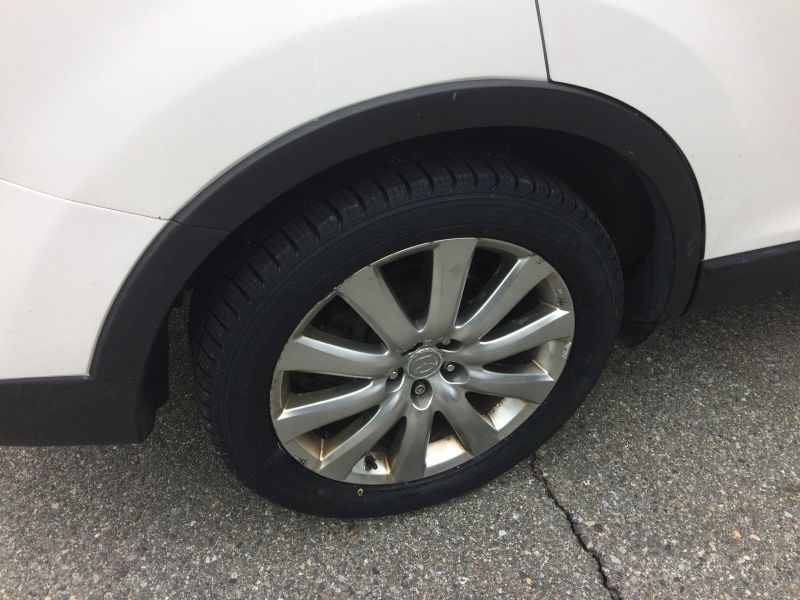 White SUV passenger side front wheel and fender flare