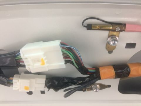 2009 Mazda CX-9 - A close-up view shows a bundle of wires connected to two white electrical connectors. The wires are wrapped in black tape and secured with…