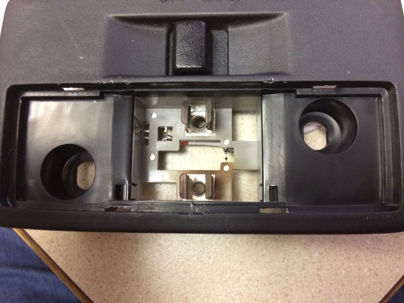 Interior of overhead console showing bulb sockets and metal contacts