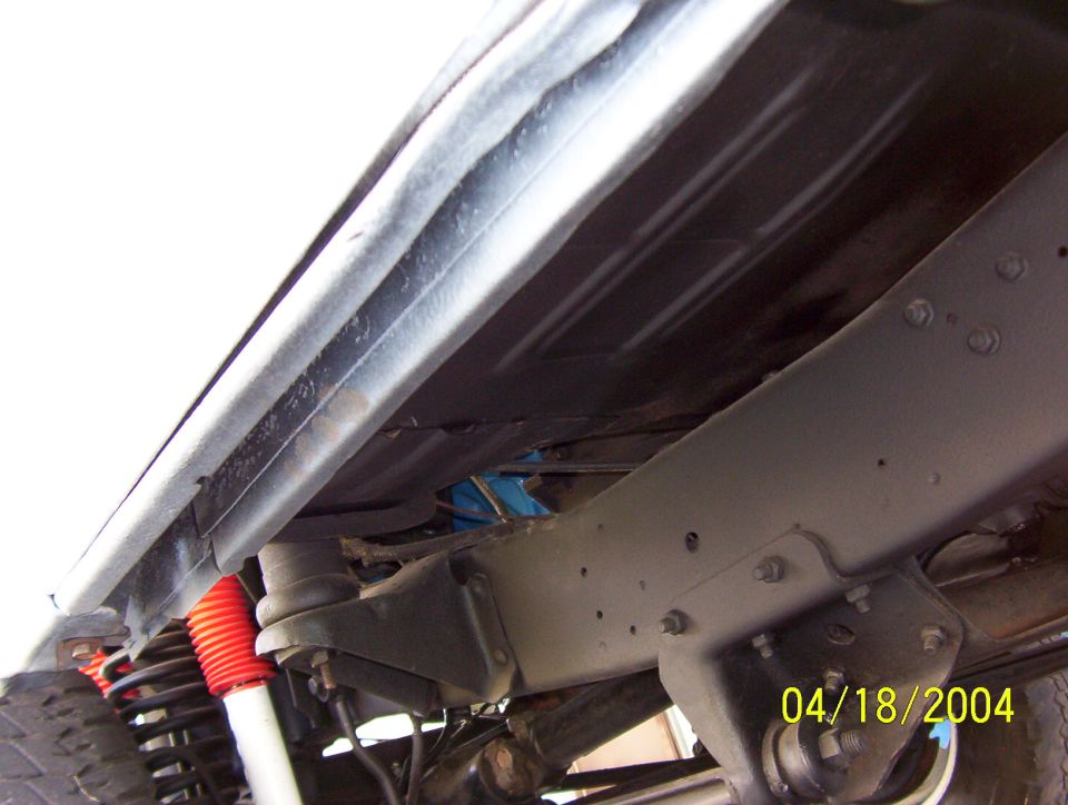 Undercarriage view of truck frame with red shock absorbers