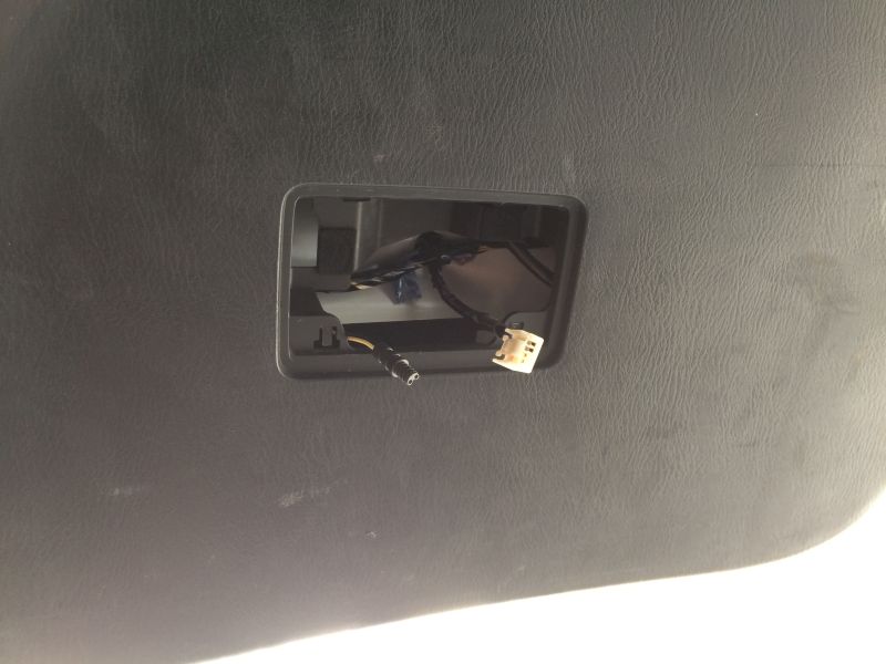 Black textured panel with cutout showing wiring and a white connector.