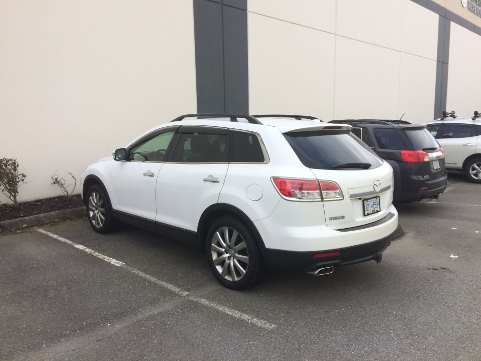 White 2009 Mazda CX-9 parked in a lot, rear-side view.