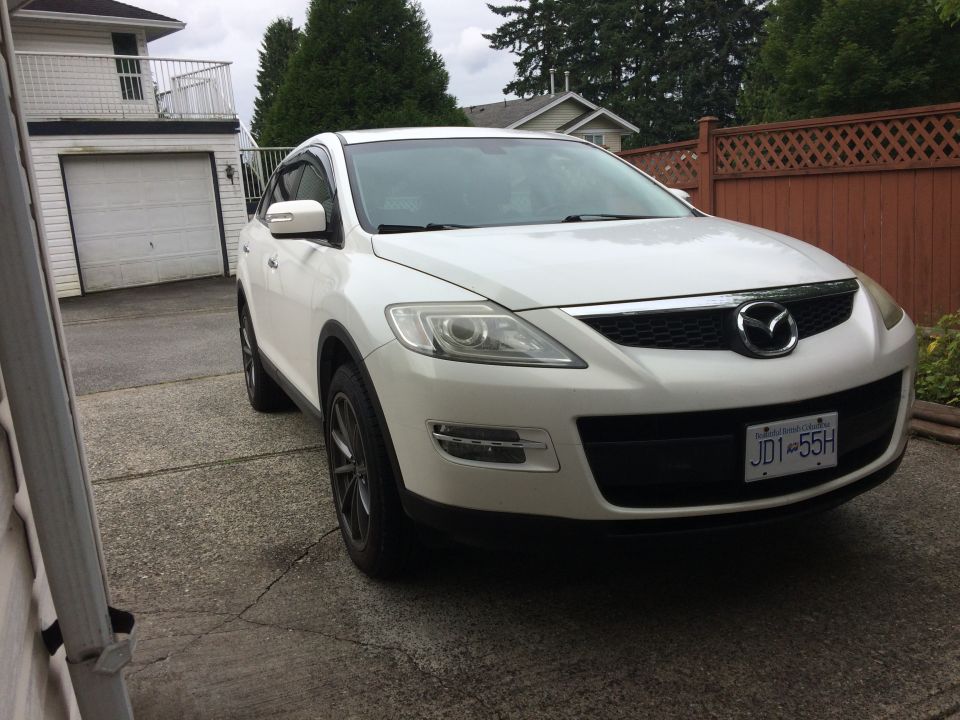 White 2009 Mazda CX-9 parked in driveway, front 3/4 view.