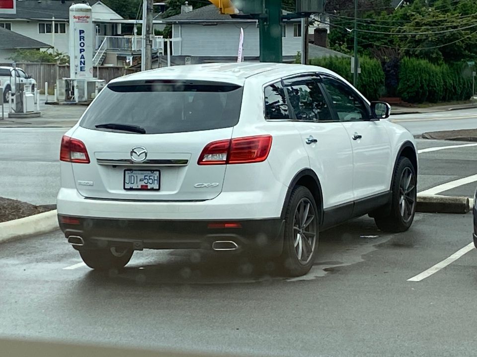 White 2009 Mazda CX-9 SUV, rear passenger side view, parked outdoors.