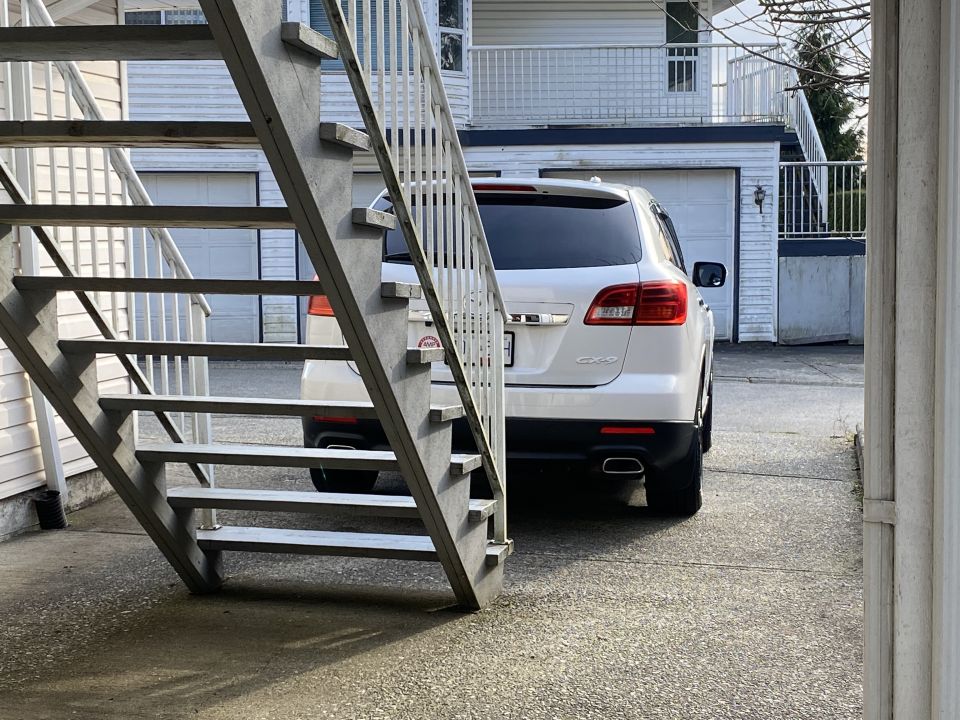 White 2009 Mazda CX-9 SUV parked outdoors next to a metal staircase.