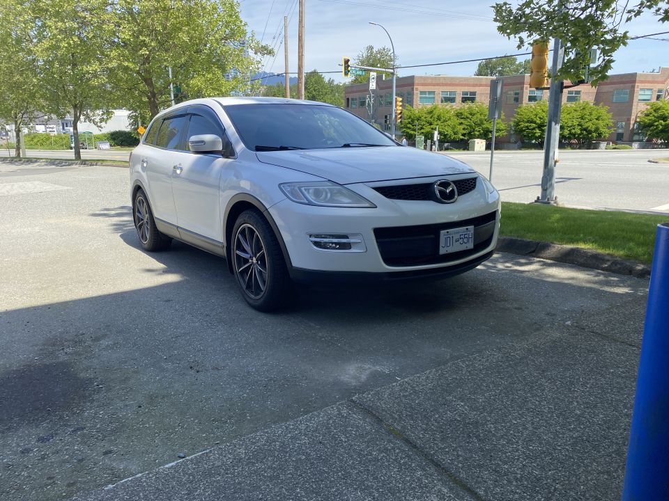 White 2009 Mazda CX-9 parked on pavement, front 3/4 view, license plate JD1-55H.