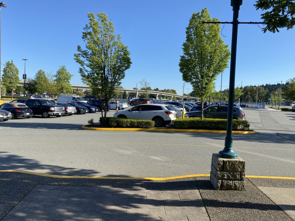 White 2009 Mazda CX-9 parked in a lot, front 3/4 view, sunny day, street lamp in foreground.
