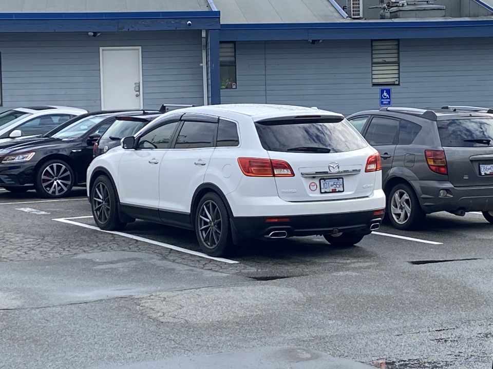 White 2009 Mazda CX-9 parked in a lot, rear-side view.