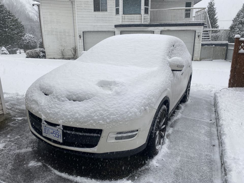 White SUV covered in snow with license plate JD1-55H