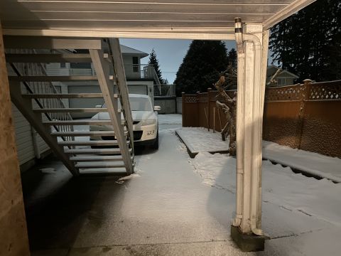 2009 Mazda CX-9 - A white Mazda CX-9 is parked on a snow-covered driveway next to an outdoor staircase. The scene appears to be a residential backyard at dus…