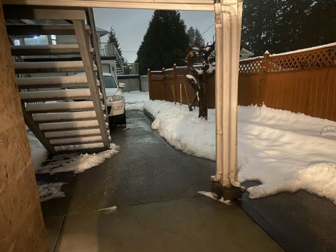 2009 Mazda CX-9 - A white 2009 Mazda CX-9 is parked on a wet driveway covered in snow, next to an outdoor staircase. The scene is set in a residential area w…