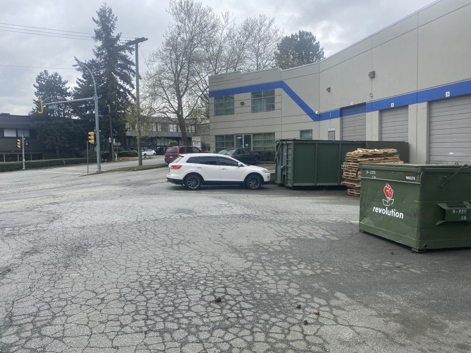 White 2009 Mazda CX-9 parked next to dumpsters.