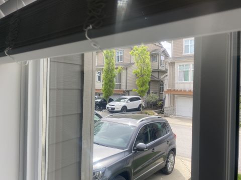 Dark gray SUV parked in front of townhouses.