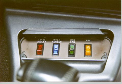 1990 Ford Thunderbird - A close-up view of a dashboard panel with four toggle switches labeled TRANS COOLER, INTER-COOLER, RAD FAN, and AUX. The switches are illum…