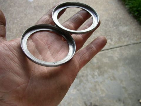 1995 Ford Bronco - Two metal rings are held in a hand, likely brake components.