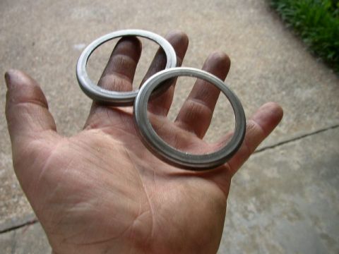 1995 Ford Bronco - Two metal rings are held in a hand, with a concrete and grass background.