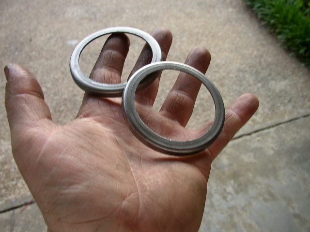 Two metal rings held in a dirty hand