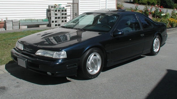 1990 Ford Thunderbird coupe, dark blue, parked in driveway