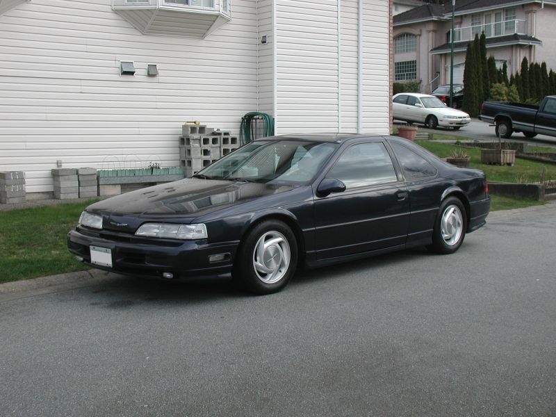 1990 Ford Thunderbird coupe, dark blue, parked on street