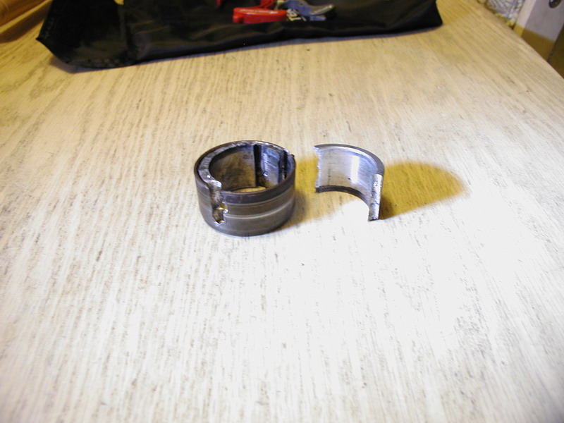 Broken metal bearing on a wooden surface.