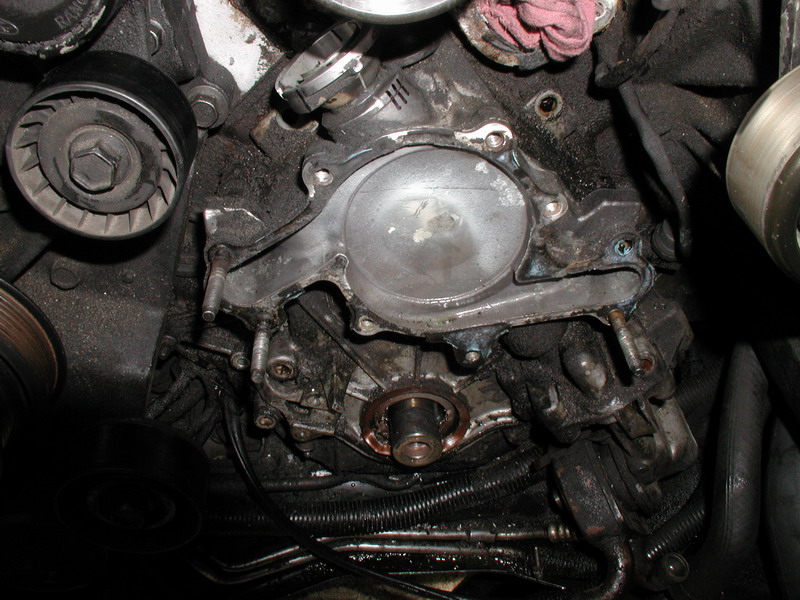 Engine bay of a Ford Thunderbird with water pump removed, showing pulleys and engine components.