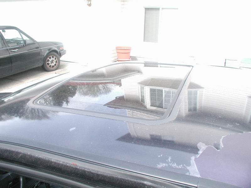 Sunroof and peeling paint on a dark colored car.