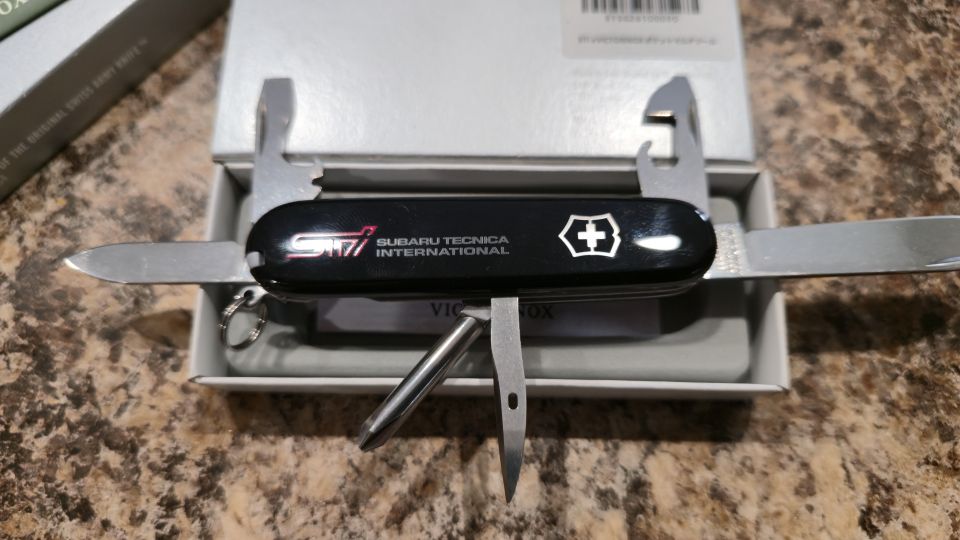 Close-up of a black Victorinox pocket knife with STI Subaru Tecnica International logo