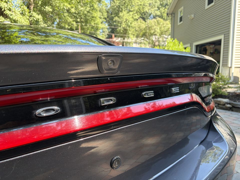 Chrome DODGE lettering on red taillight bar with trunk-lip backup camera
