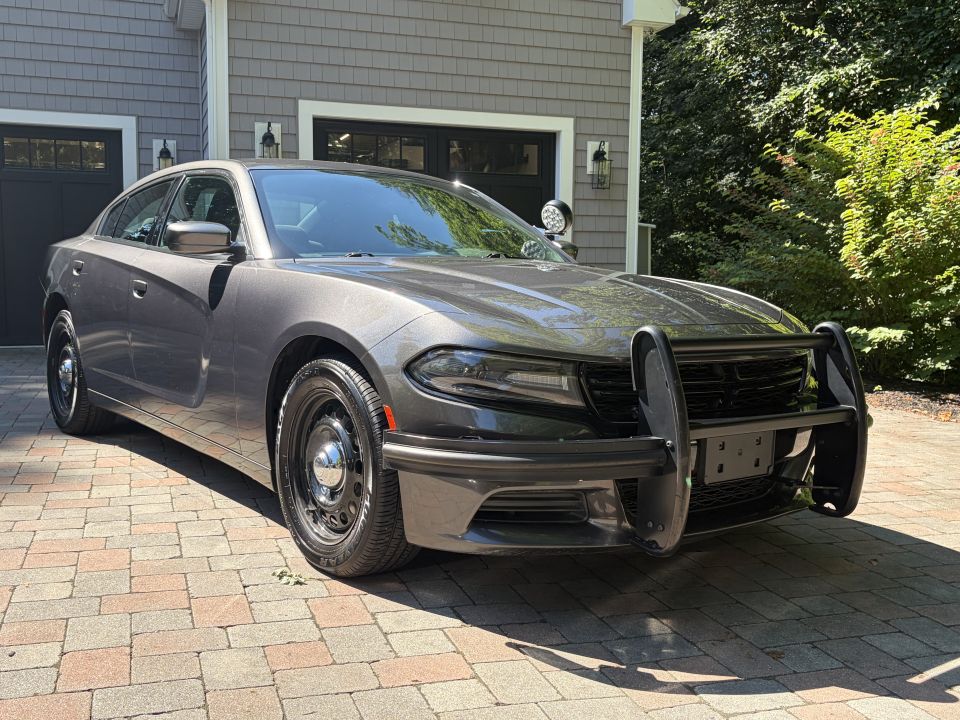 Dark gray Dodge Charger with push bumper, steel wheels and pillar spotlight