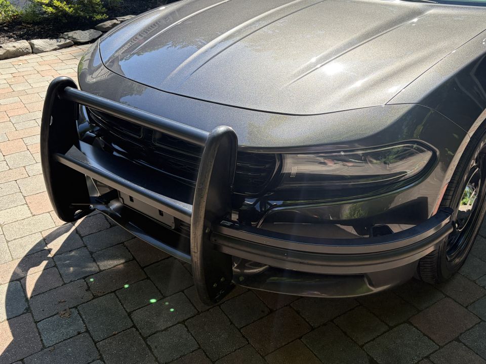 Black push bumper mounted on the front of a dark gray Dodge Charger
