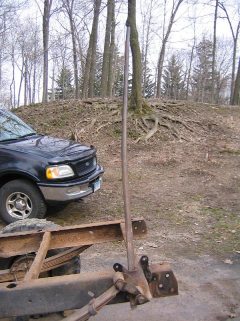1978 Ford Bronco - A black 1997 Ford F-150 is parked next to its frame, with a wooded hill behind them.
