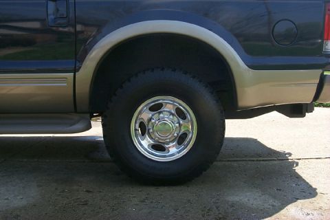 2003 Ford Excursion - The rear wheel and two-tone paint scheme of a Ford Excursion are visible.