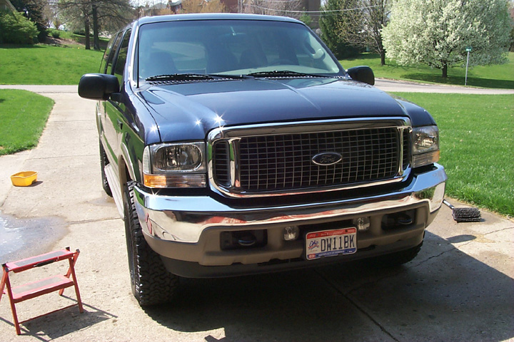 Dark blue Ford Excursion SUV front view with chrome grille and Ohio plate on a driveway