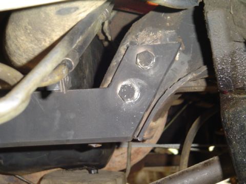 1993 Ford Bronco - Close-up view of a vehicle's undercarriage, focusing on a bolted metal bracket.