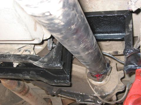 1985 Ford Bronco - Close-up view of a driveshaft U-joint, showing red grease applied to the fittings.