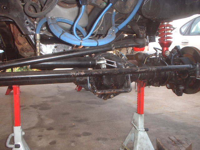 Underside of Bronco front axle and differential on jack stands with red shock