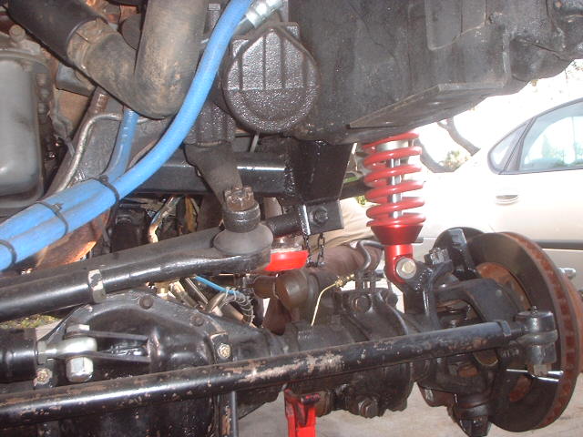 Front axle and suspension with red coilover shock and disc brake under a Ford Bronco