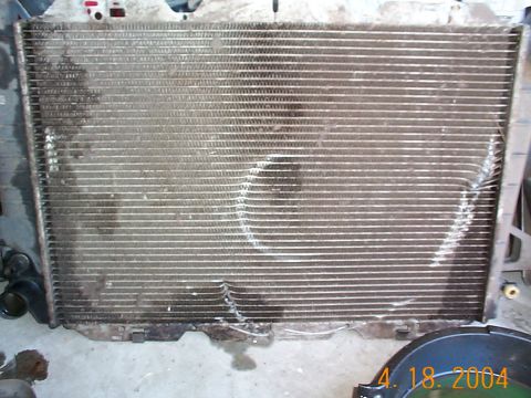 1992 Ford Bronco - This is a close-up of a damaged vehicle radiator, showing bent fins and dirt accumulation.