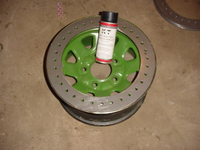 Green wheel with a can of spray paint on it. Another wheel is visible in the background