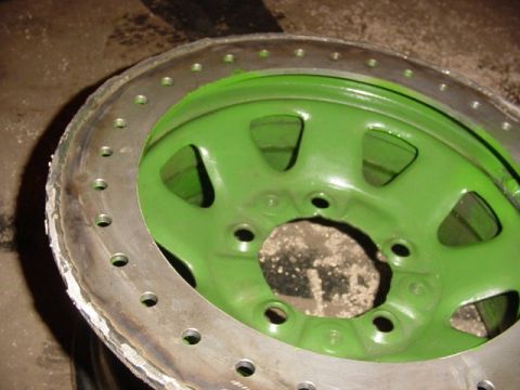 1992 Ford Bronco - A close-up view of a custom beadlock wheel, painted green, with a silver outer ring.