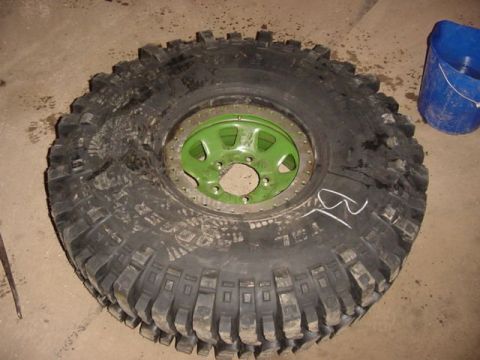 1992 Ford Bronco - A tire with a green rim and heavy-duty tread is shown, likely a custom modification.